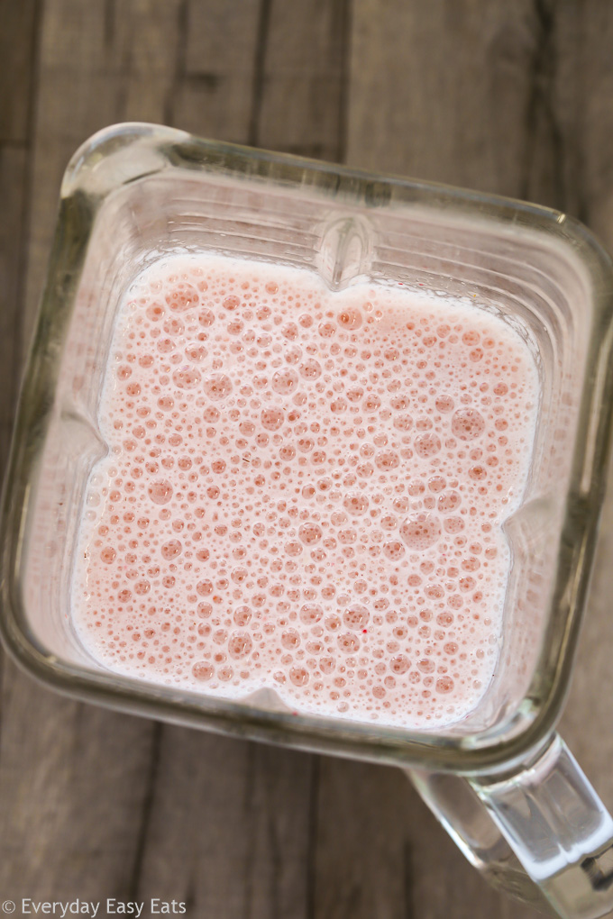 Close-up overhead view of Strawberry Protein Smoothie ingredients in a blender after blending.