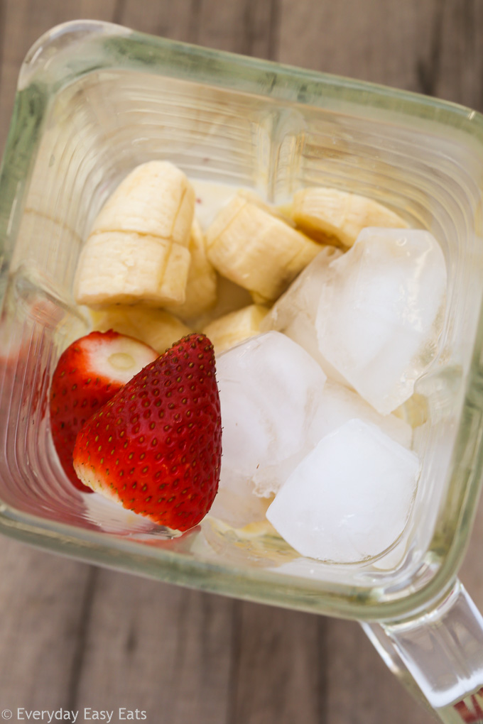 Close-up overhead view of Strawberry Protein Smoothie ingredients in a blender before blending.