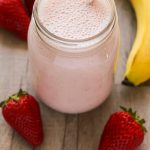 Close-up overhead view of a Strawberry Protein Shake in a glass jar with title text overlay.