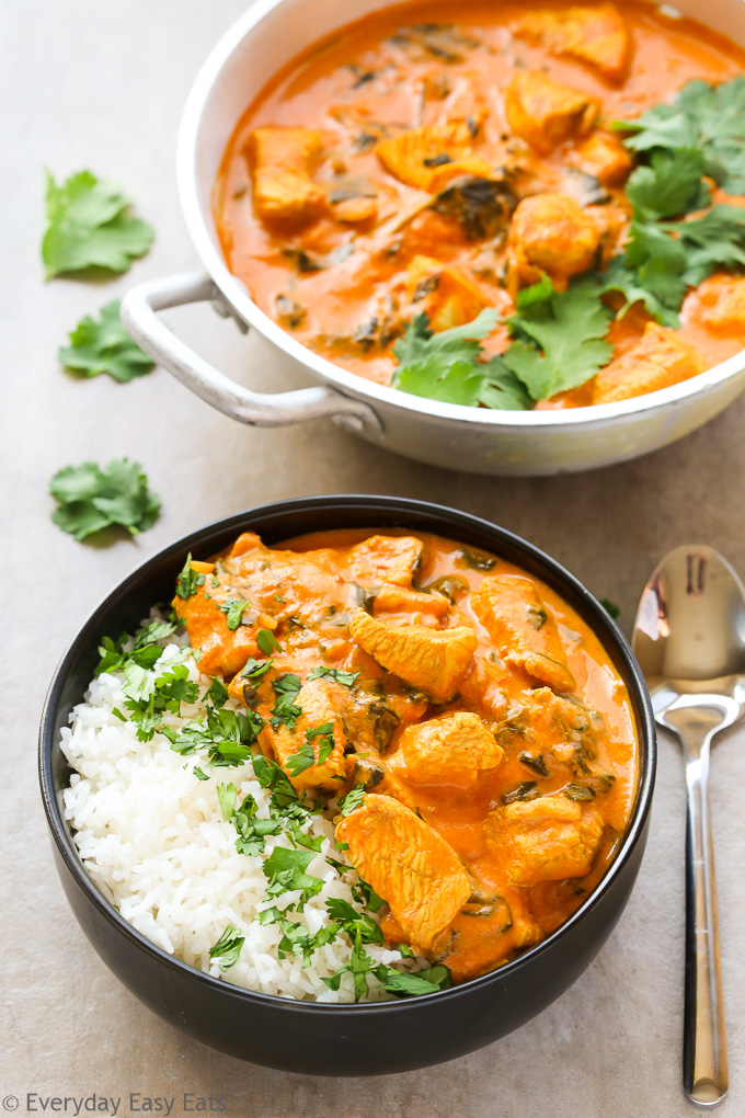 Overhead view of Indian Coconut Chicken Curry with white rice in a bowl with a spoon on the side.