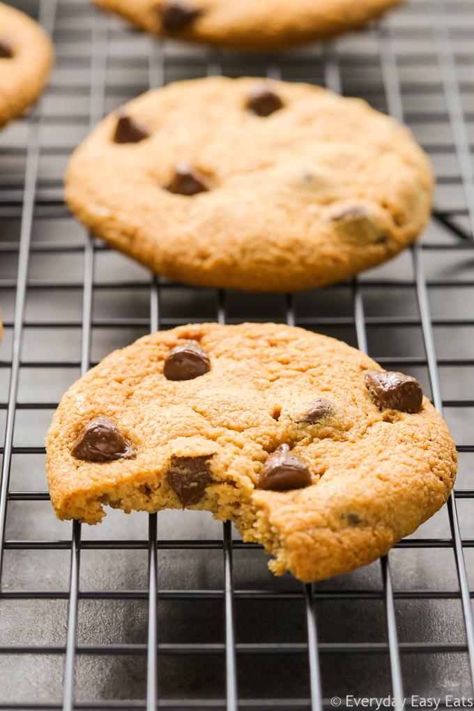 Close-up side view of a Peanut Butter Cookie with a bite taken out of it on wire cooling rack.