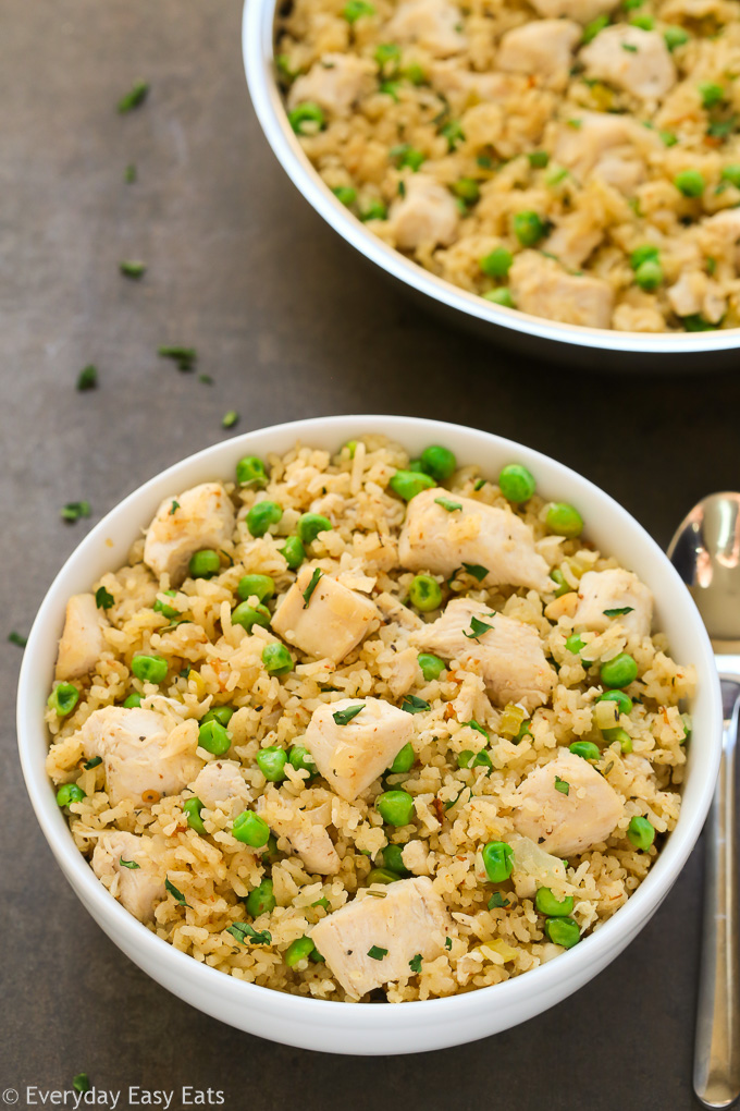 Overhead view of One-Pan Chicken and Rice in a white bowl with a spoon on the side.