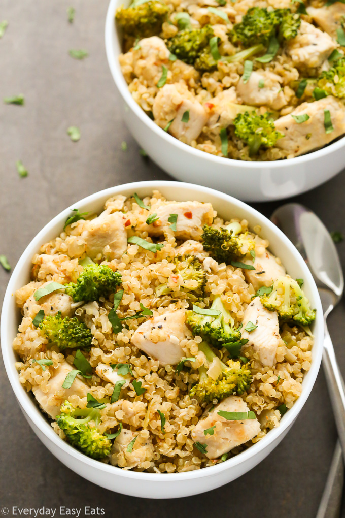 Overhead view of One-Pan Chicken Broccoli Quinoa in a white bowl on a black surface.