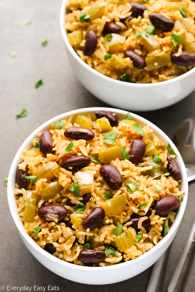 Overhead view of two bowls of Vegetarian Dirty Rice on a dark surface.